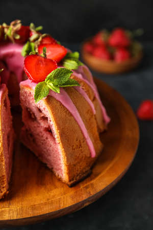 Wooden dessert stand with tasty strawberry cake on table, closeup