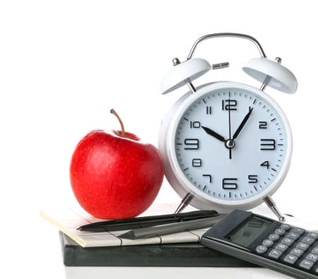School stationery with apple and alarm clock on white background