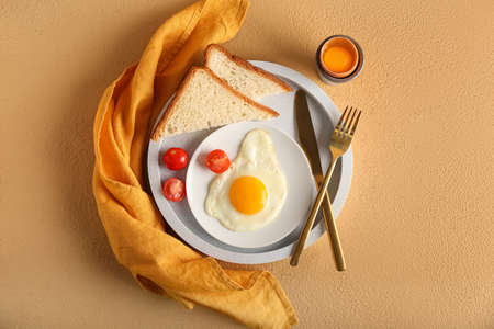 Tray with delicious breakfast on color background
