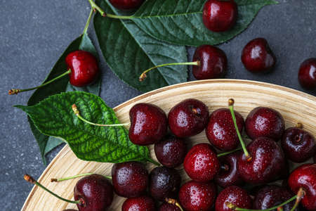 Plate with ripe cherries on table, closeup