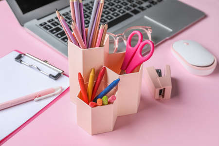 Holder with different stationery on pink background, closeup