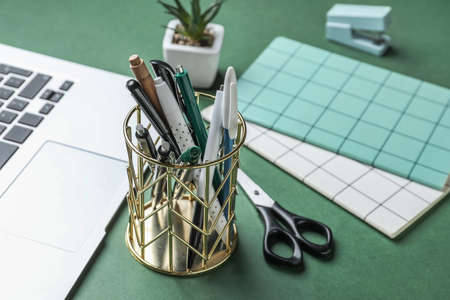 Holder with different pens on table