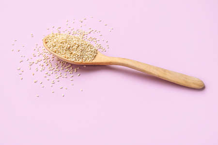 Wooden spoon with sesame seeds on color backgroundの写真素材