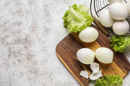 Composition with boiled and raw chicken eggs on light background