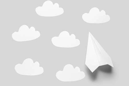 Paper plane and clouds on gray backgroundの写真素材