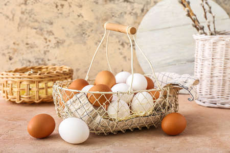 Basket with chicken eggs on beige table