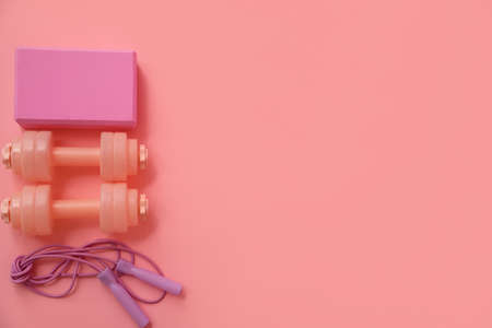 Set of sports equipment on pink background