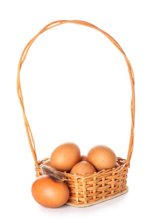Wicker basket with brown chicken eggs isolated on white backgroundの写真素材