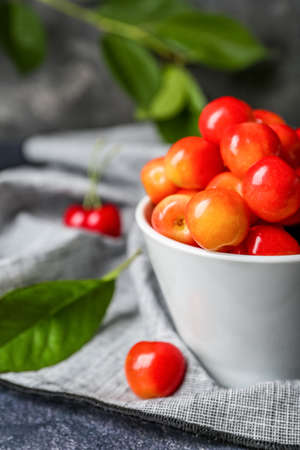 Bowl of sweet cherries on grunge background, closeup