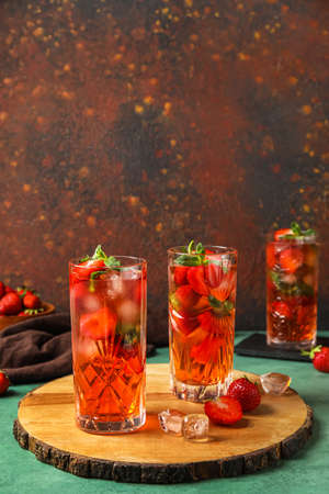 Board with glasses of strawberry lemonade on green table against grunge backgroundの写真素材