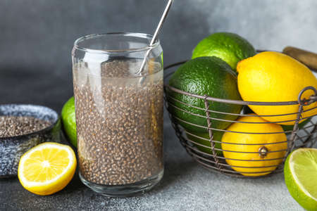 Glass of water with chia seeds and citrus fruits on black and white backgroundの写真素材