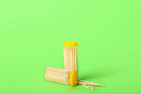 Holders with wooden toothpicks on green background