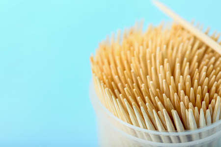 Holder with toothpicks on blue background, closeup