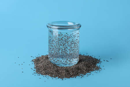 Glass of water with chia seeds on blue backgroundの写真素材