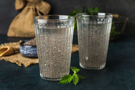 Glasses with water and chia seeds on dark backgroundの写真素材