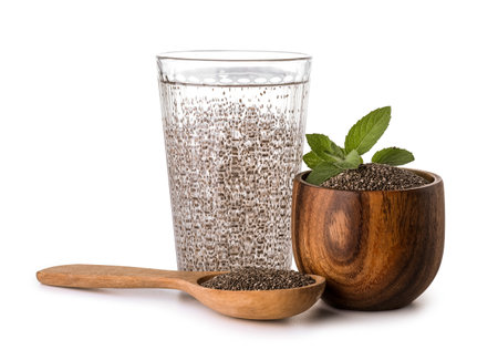Glass of water, spoon and bowl with chia seeds on white backgroundの写真素材