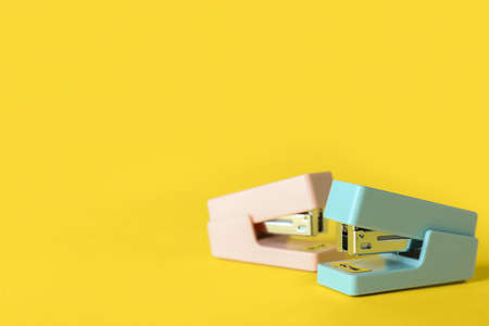 Colorful staplers on yellow backgroundの写真素材