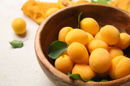 Bowl of ripe apricots on light background, closeupの写真素材