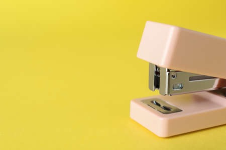 Pink stapler on yellow background, closeupの写真素材