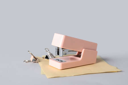 Stapler with sticky notes and paper clips on white backgroundの写真素材