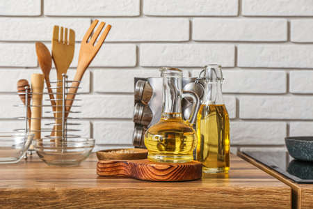 Bottles of sunflower oil with board on table near white brick wallの写真素材