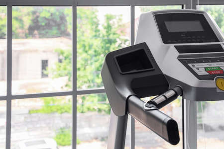 Modern treadmill near window in gym, closeup