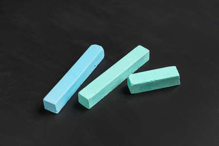 Pieces of blue chalk on blackboard
