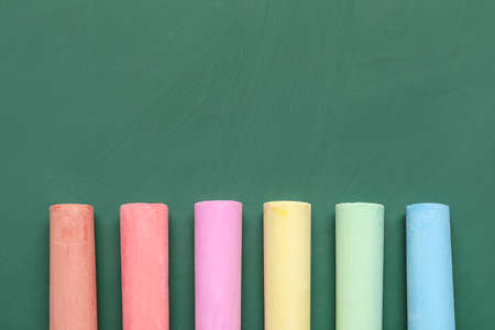 colorful chalks on green blackboard