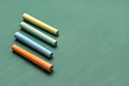 colorful chalks on green blackboardの写真素材