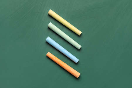 colorful chalks on green blackboard