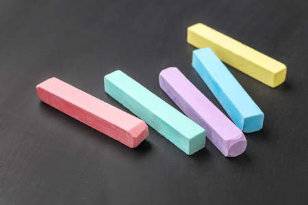 Colorful chalks on blackboard, closeup