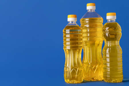 Bottles of sunflower oil on blue background