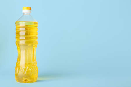 Bottle of sunflower oil on blue background