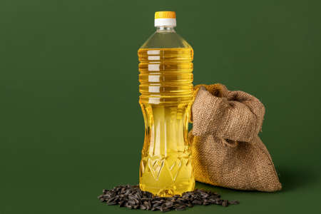 Bottle of oil, sack bag and sunflower seeds on green backgroundの写真素材