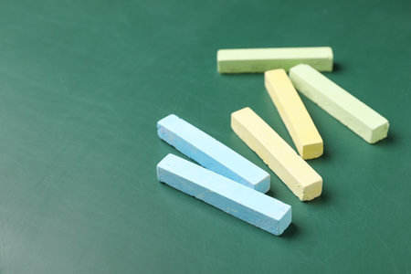 colorful chalks on green blackboard