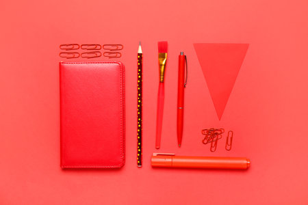 Paper clips with stationery on red background