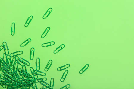Green paper clips on color backgroundの写真素材