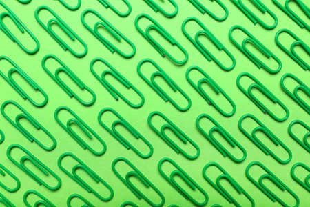 Green paper clips on color backgroundの写真素材