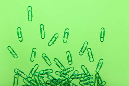 Green paper clips on color backgroundの写真素材