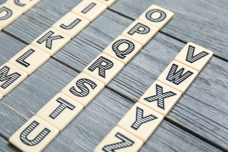Different letters on gray wooden background. Alphabet conceptの写真素材