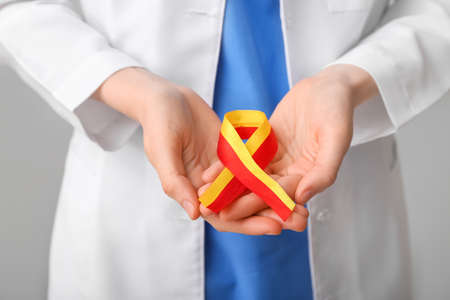 Female doctor with awareness ribbon on gray background, closeup. Hepatitis conceptの写真素材