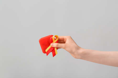 Woman with awareness ribbon and pills on gray background. Hepatitis conceptの写真素材
