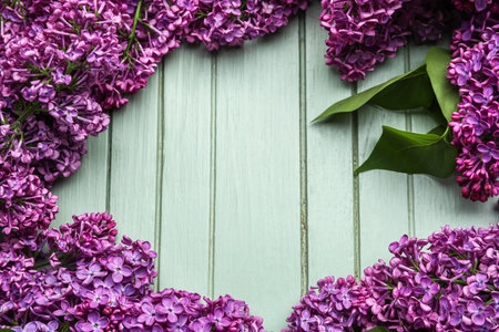 Frame made of purple lilac flowers on green wooden backgroundの写真素材