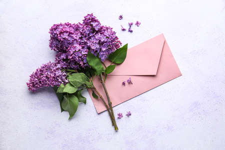 Purple lilac flowers with envelope on white background