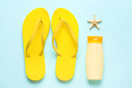 Bottle of sunscreen with flip flops and starfish on blue backgroundの写真素材