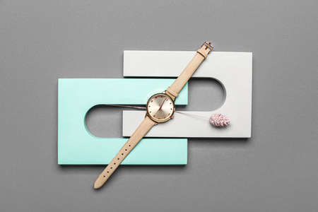 Composition with showcase pedestal, wristwatch and floral decor on gray backgroundの写真素材