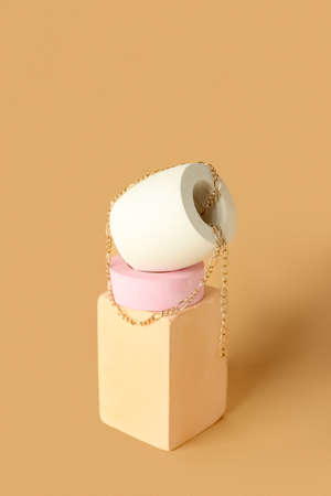 Composition with showcase pedestal and necklace on beige background