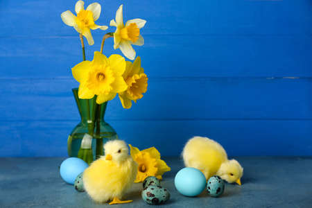 Cute chickens, Easter eggs and flowers on tableの写真素材
