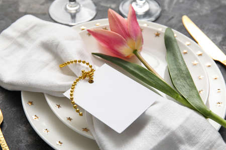 Table setting with tulip and blank card, closeup