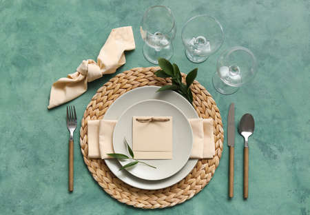 Table setting with blank card on green backgroundの写真素材